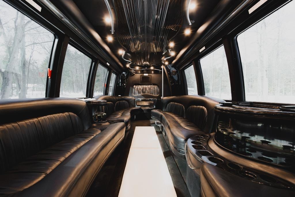 Miami Limo Bus interior — black leather seating with panoramic windows and illuminated floor